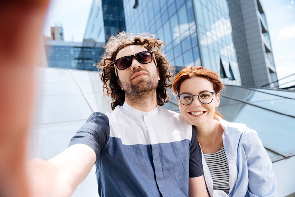 Handsome curly man making photo with his appealing woman - Zdjęcie, obraz