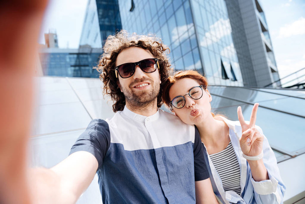 Young woman wearing glasses making funny face for selfie - Photo, image