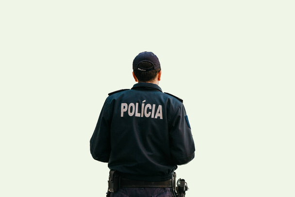 Απομονωμένα σε λευκό φόντο, ένας αστυνομικός στέκεται με την πλάτη στο ειδικό ρούχα με την επιγραφή αστυνομία στα πορτογαλικά και Ισπανικά - Φωτογραφία, εικόνα