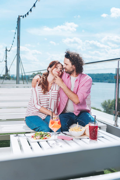 Nettes Paar beim romantischen Abendessen auf der Terrasse mit Meerblick - Foto, Bild