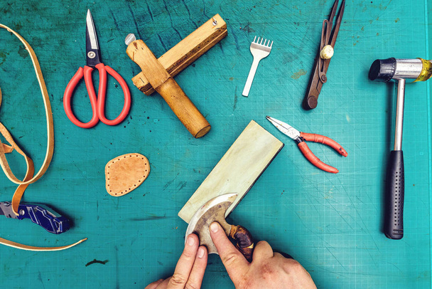 Leder Handwerker Schleifmaterial. Werkstattlabor mit Instrumenten. Blick von oben, grüner Tisch - Foto, Bild