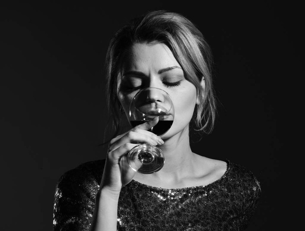 Girl holding glass of red wine on dark blue background - Foto, afbeelding