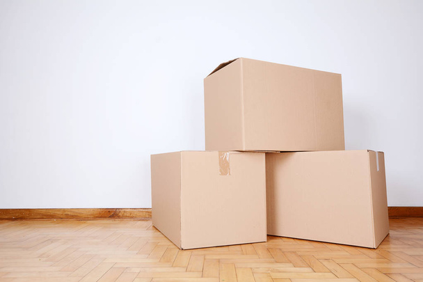 Stack of cardboard boxes in the empty room with copy space. Move concept - Foto, Imagem