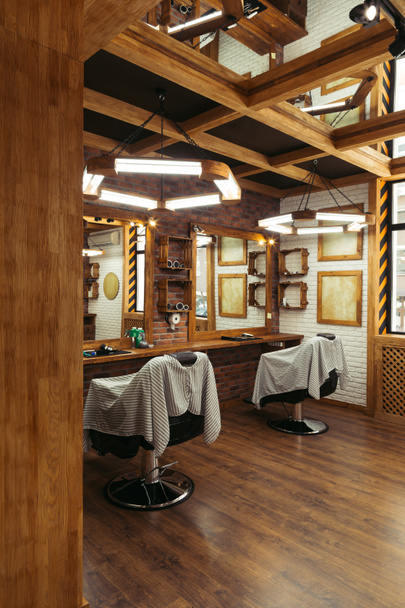empty chairs and mirrors in modern barbershop  - Zdjęcie, obraz