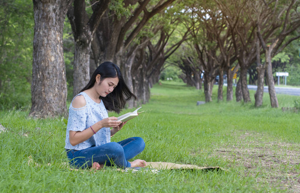Asian women sit reading at the park. - Photo, Image