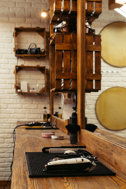 outils de coiffeur professionnels sur étagère en bois et miroir au salon de coiffure moderne
 - Photo, image