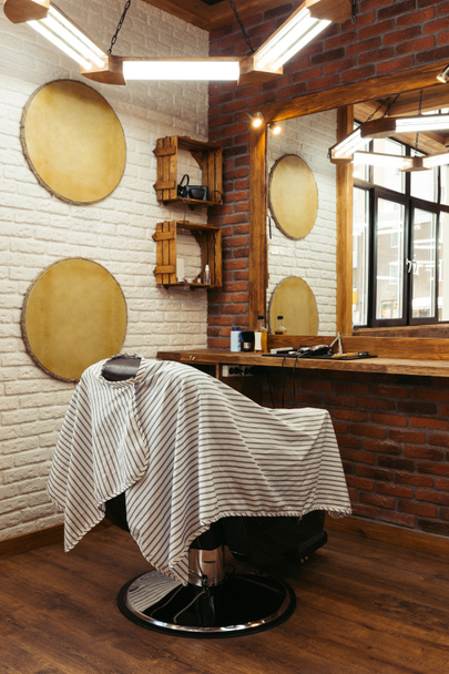 moderno barbearia interior e ferramentas profissionais na prateleira de madeira perto do espelho
 - Foto, Imagem