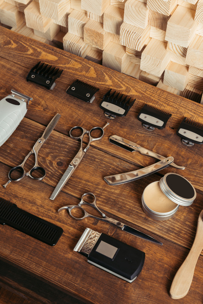 high angle view of various professional barber tools on wooden surface in hair salon   - Fotografie, Obrázek