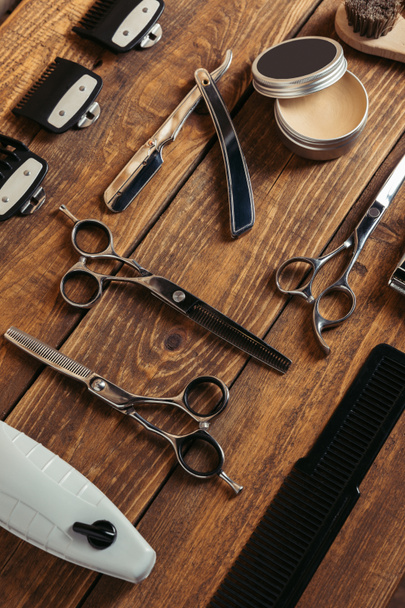 high angle view of various professional barber tools on wooden surface in barbershop - Photo, Image