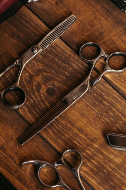 high angle view of professional scissors on wooden surface in barbershop  - Valokuva, kuva