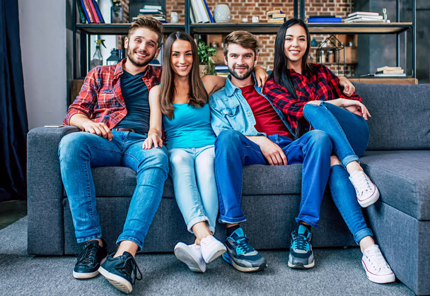 Group of young happy friends posing in living room - Foto, afbeelding
