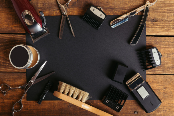 vista dall'alto di vari strumenti da barbiere professionali su carta nera su superficie di legno
 - Foto, immagini