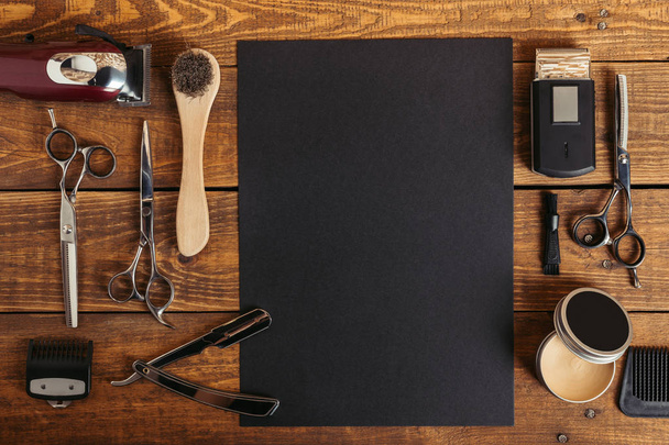 vista dall'alto di strumenti da barbiere professionali e carta nera vuota sul tavolo di legno
   - Foto, immagini