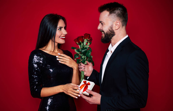 Young beard man gifting rose bouquet to girlfriend - Foto, Imagem