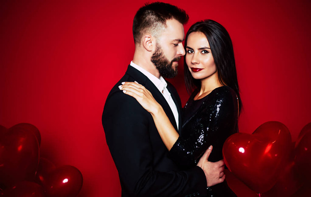 Young caucasian couple posing over red background - 写真・画像