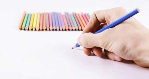 closeup.womans hand draws a blue pencil on a white sheet of pap - Fotó, kép