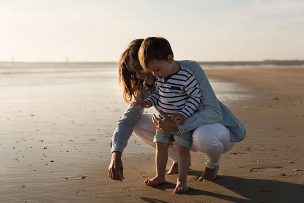 Giovane madre esplorare la spiaggia con il bambino
 - Foto, immagini
