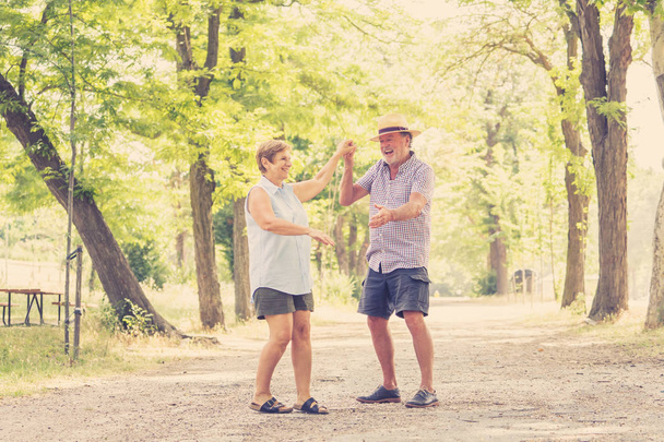 Joyeux couple de personnes âgées souriantes amoureux, dansant et s'amusant dans le parc
. - Photo, image