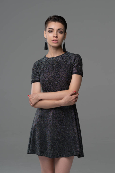 young beautiful girl posing in studio, standing in dress - Фото, изображение