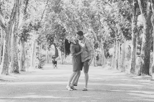 Happy couple dancing and having fun together in a beautiful green park - Photo, Image