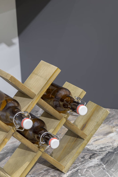 Holzständer für Flaschen auf dem Tisch in der Küche. - Foto, Bild