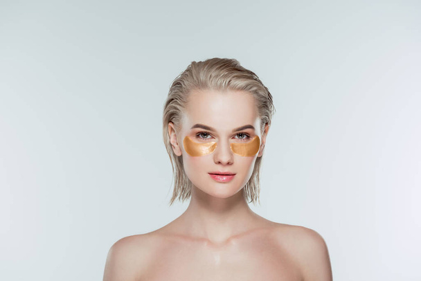 nude woman with golden eye patches, isolated on grey - Photo, Image