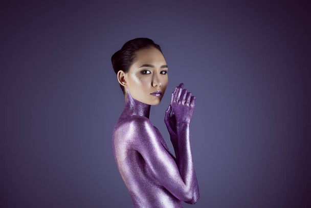 attractive naked fashionable asian girl in ultra violet glitter, isolated on purple - Foto, Imagem