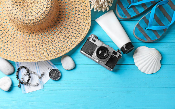 Composition with camera and beach accessories on color wooden background - Photo, Image