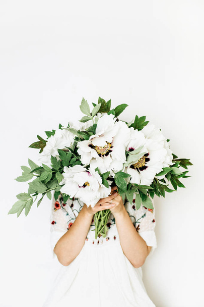 Young woman holding white peonies bouquet on white background. - Φωτογραφία, εικόνα