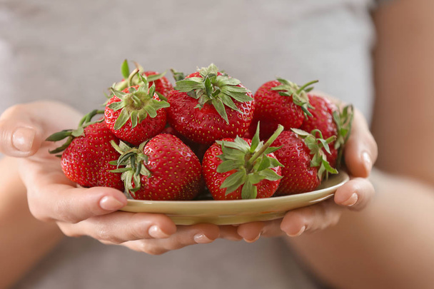 Woman holding plate with ripe red strawberries, closeup - Zdjęcie, obraz