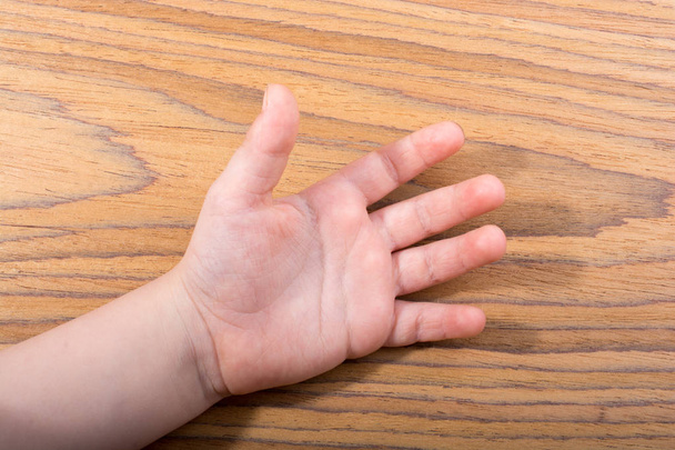 Bébés main ouverte avec cinq doigts sur la texture en bois
 - Photo, image