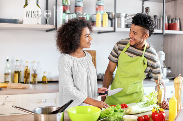 Young African-American couple cooking together in kitchen - Photo, Image