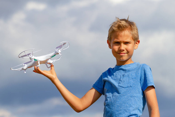 Το παιδί παίζει με drone σε εξωτερικούς χώρους κατά της μπλε του ουρανού - Φωτογραφία, εικόνα