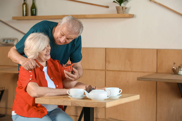 Feliz pareja de ancianos sentados juntos en la cafetería
 - Foto, imagen