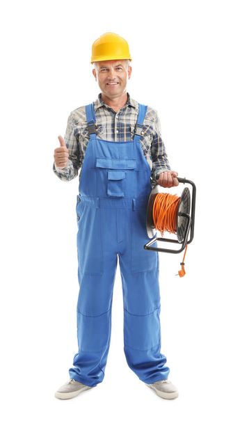 Mature male electrician with extension cord reel showing thumb-up gesture on white background - Photo, image
