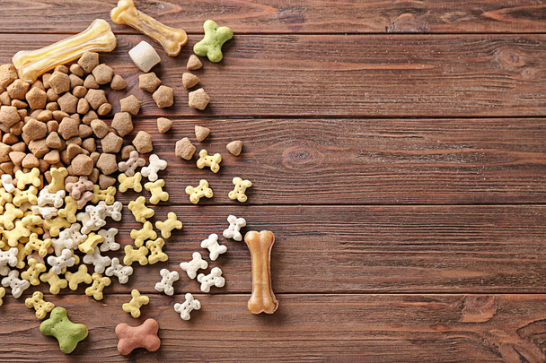 Купа кормів для домашніх тварин на дерев'яному тлі
 - Фото, зображення
