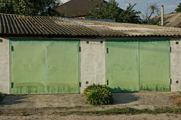 fachada de garaje con dos puertas de hierro dorado en la calle
 - Foto, Imagen