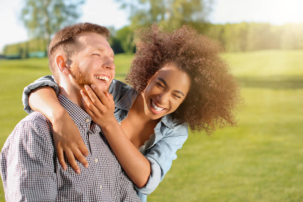 Young loving interracial couple outdoors on spring day - Photo, image