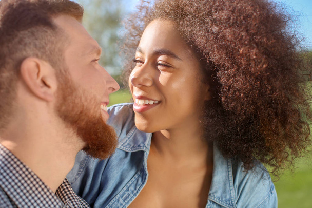 Young loving interracial couple outdoors on spring day - Photo, Image