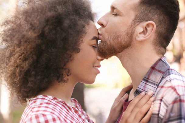 Jeune homme embrassant sa belle petite amie afro-américaine en plein air
 - Photo, image