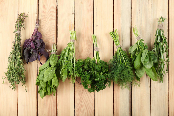 Bunches of different herbs on wooden background - Fotografie, Obrázek