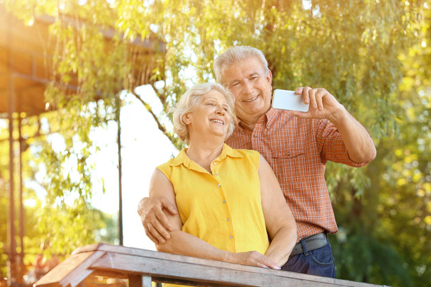 Gelukkig ouder paar nemen selfie in park - Foto, afbeelding