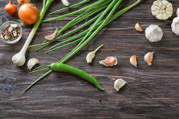 Composition with fresh garlic, green onion and spices on wooden background - Valokuva, kuva