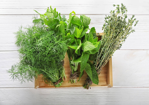 Crate with different fresh herbs on white wooden background - Foto, imagen