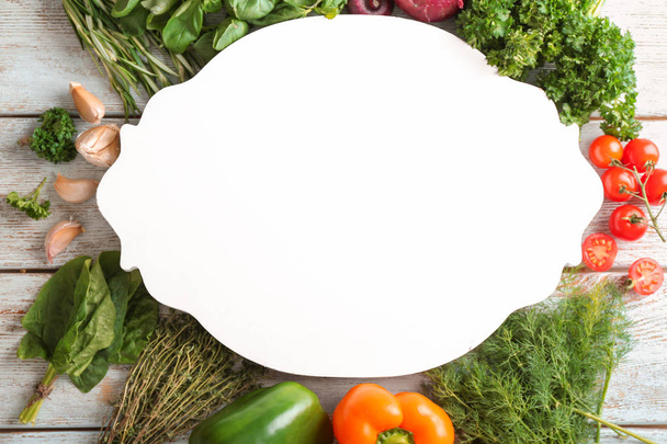 Composition with board, different fresh herbs and vegetables on wooden background - Photo, Image