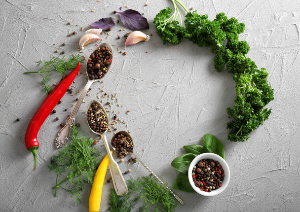 Frame made of different fresh herbs, spices and chili peppers on grey background - Foto, immagini