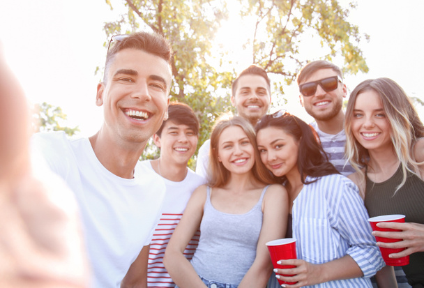 Groupe de jeunes attractifs prenant selfie à l'extérieur
 - Photo, image