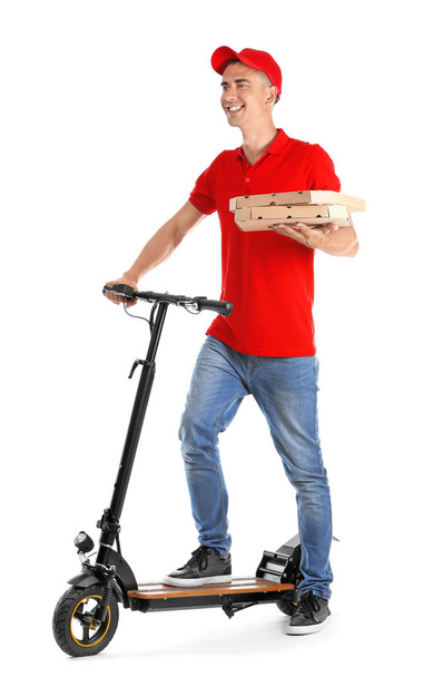 Joven con cajas de pizza y patada scooter sobre fondo blanco. Servicio de entrega de alimentos
 - Foto, Imagen