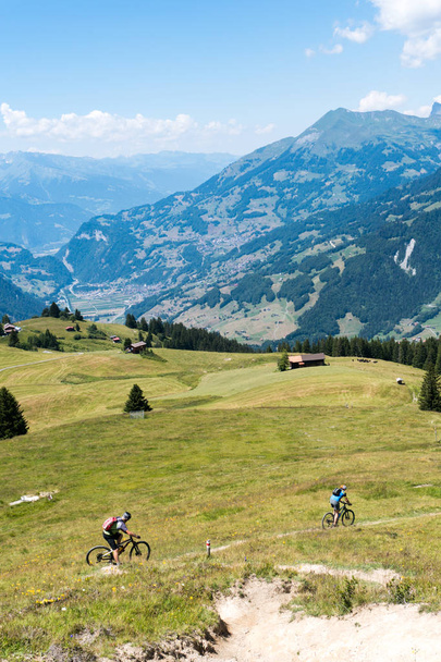 пенсионеры на горных велосипедах в идиллическом альпийском ландшафте в Швейцарии возле Клостерс
 - Фото, изображение