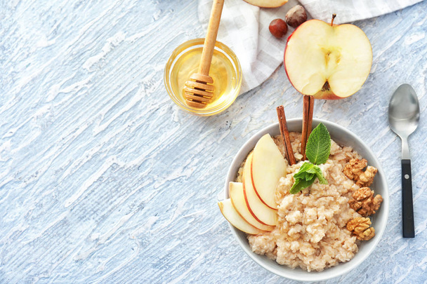 Tasty oatmeal with apple and walnut in bowl on table - Photo, Image